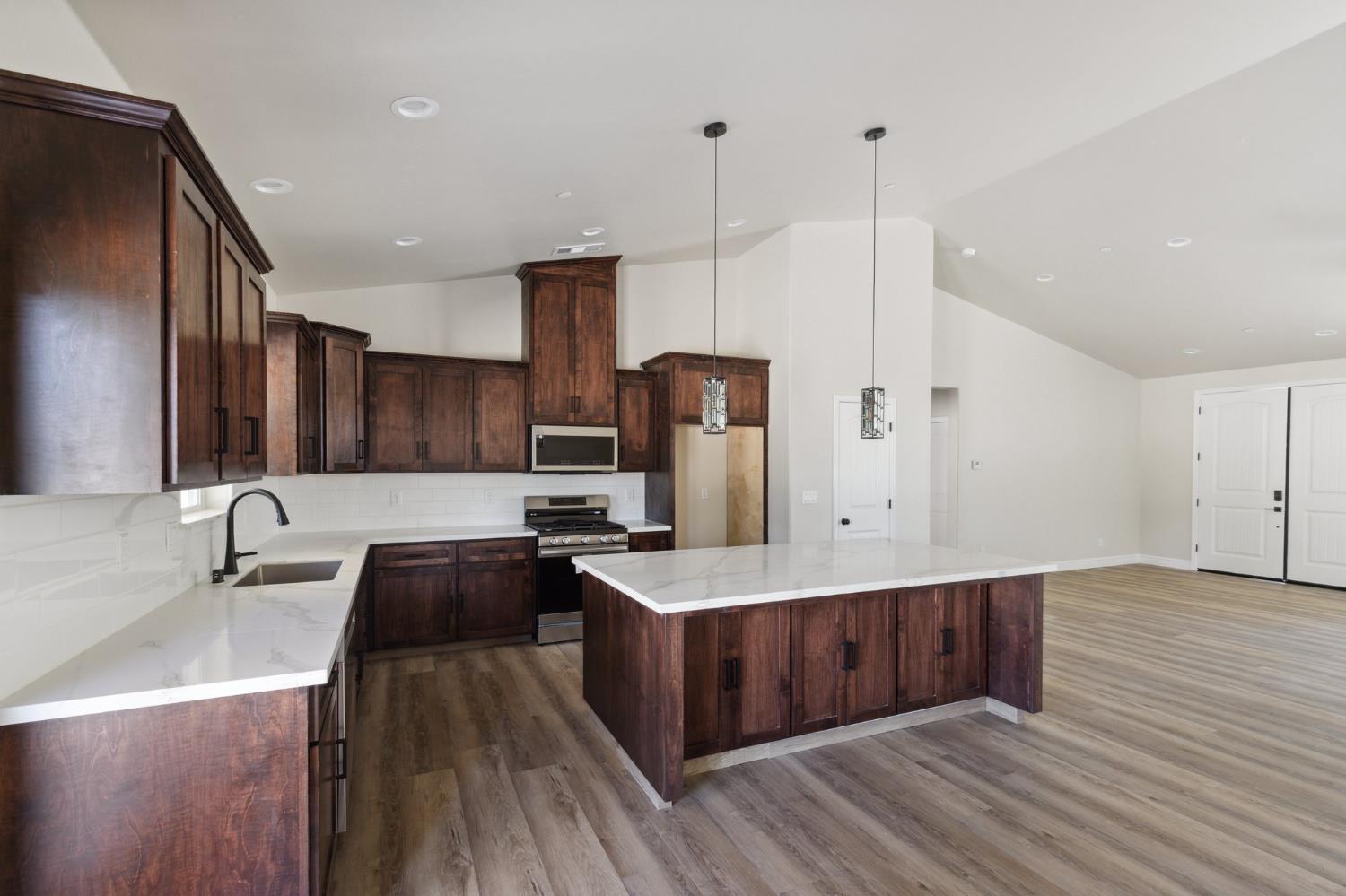 31007 Revis Road Coarsegold, CA 93614 - Photo 10 of 41 a kitchen with stainless steel appliances granite countertop a sink a stove and a wooden floors