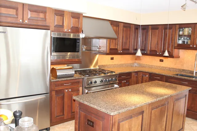 a kitchen with stainless steel appliances granite countertop a sink stove and refrigerator