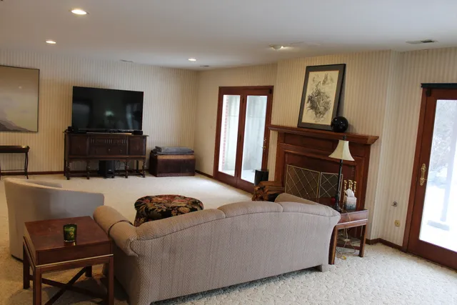 a living room with furniture a flat screen tv and a fireplace