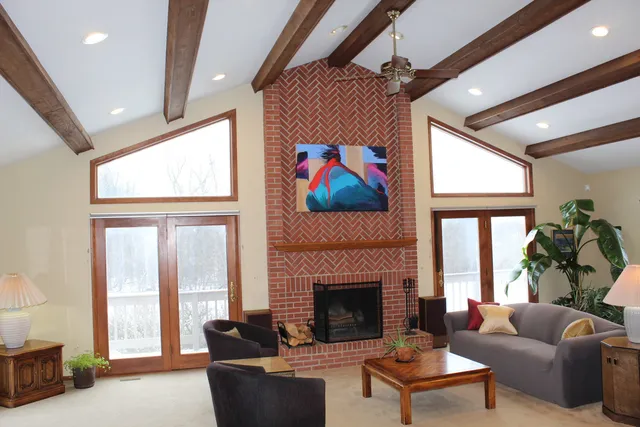 a living room with furniture a large window and a fireplace