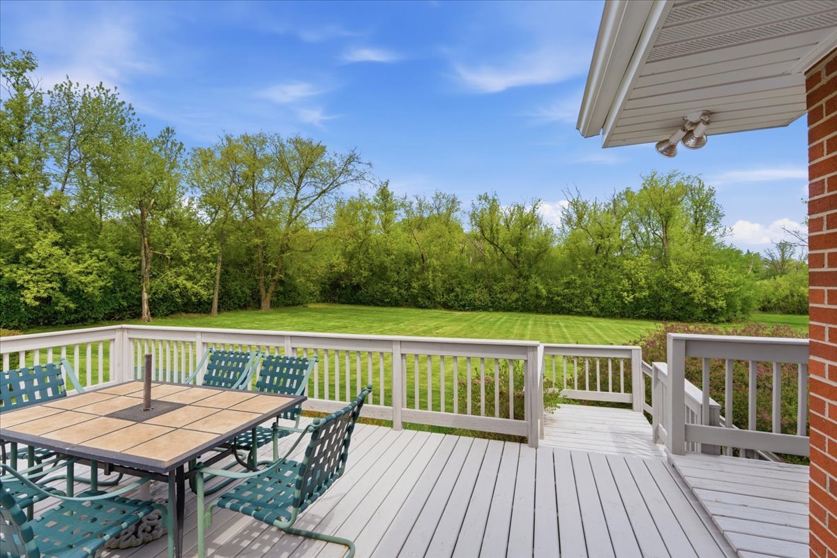 520 Merri Oaks Road Barrington Hills, IL 60010 - Photo 35 of 43 a view of a deck with wooden floor and fence with a table and chairs