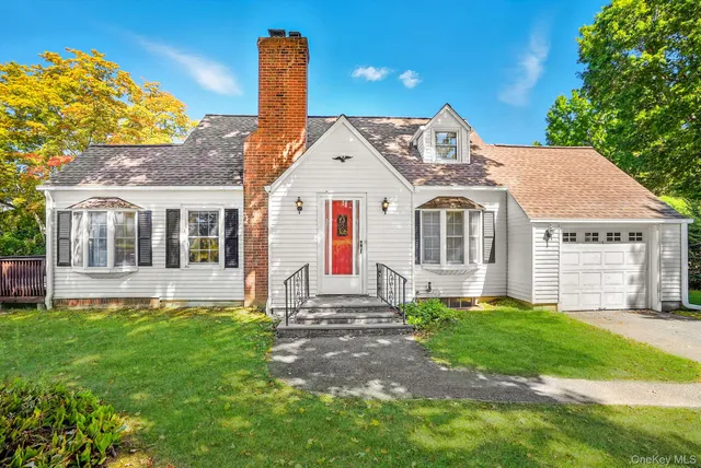 a front view of a house with a garden and yard