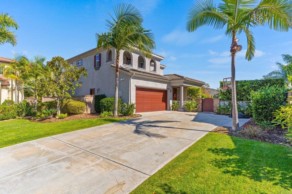 a front view of a house with a garden and palm trees