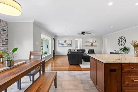 a kitchen with kitchen island granite countertop a sink stove and cabinets