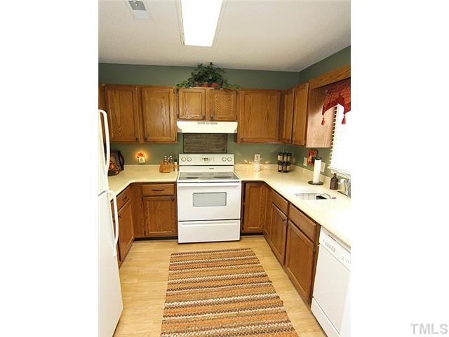1906 Township Circle Raleigh, NC 27609 - Photo 5 of 12 Plenty of Cabinets with Solid Surface Counter Tops & Laminate Floors which Lead from the Foyer Entrance.