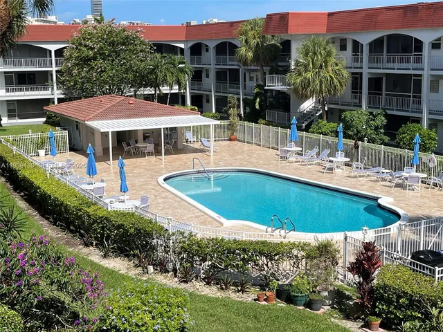 a view of a swimming pool with a patio and plants