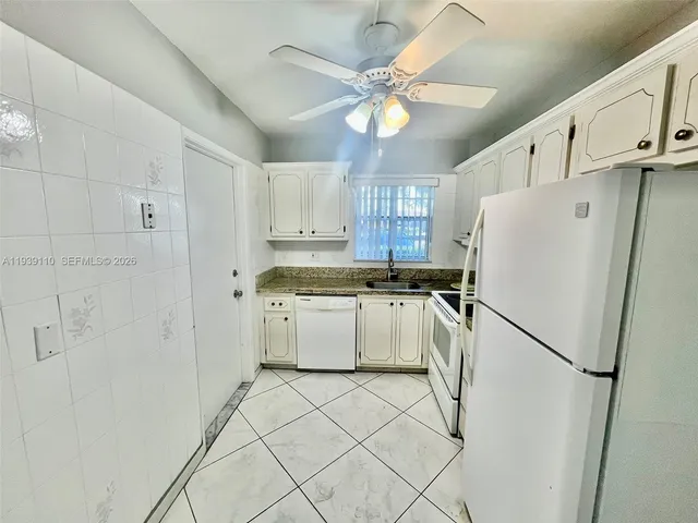 a white refrigerator freezer sitting inside of a kitchen