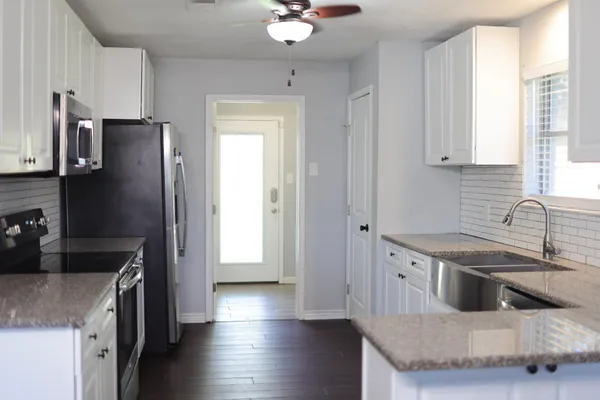 a kitchen with stainless steel appliances white cabinets and a sink