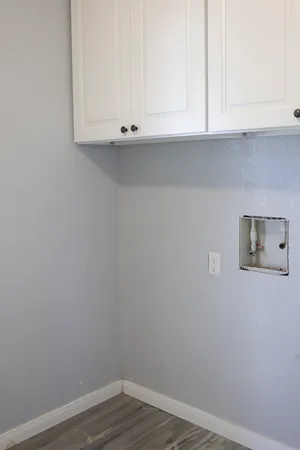 an empty room with a window and a chandelier fan