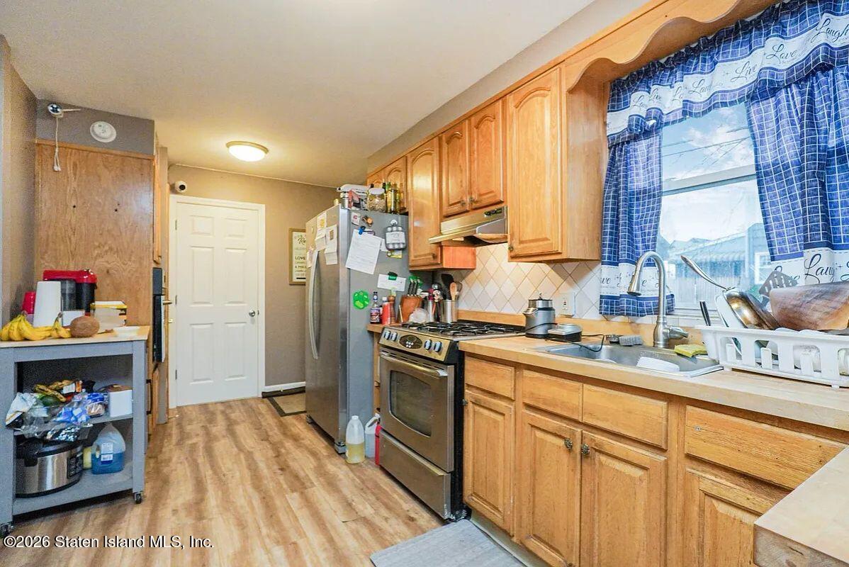 202 Watchogue Road Staten Island, NY 10314 - Photo 12 of 19 a kitchen with stainless steel appliances granite countertop a sink stove and refrigerator