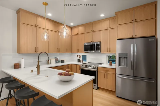 a kitchen with stainless steel appliances a refrigerator sink stove microwave and cabinets