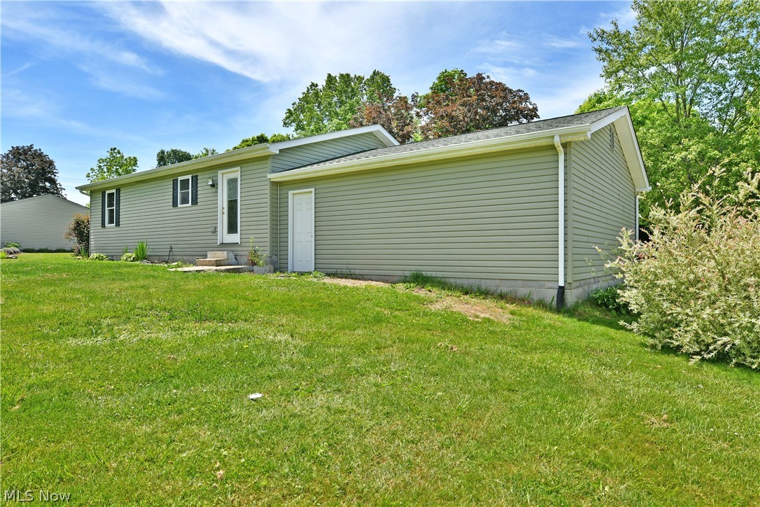 754 Warner Road Hubbard, OH 44425 - Photo 46 of 46 Exterior featuring light green horizontal siding, white trim, and a white entry door with a storm door