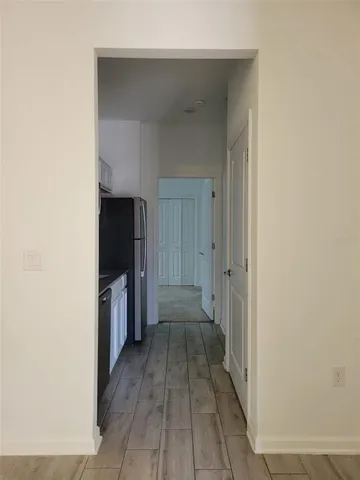 a view of a hallway with wooden floor and staircase