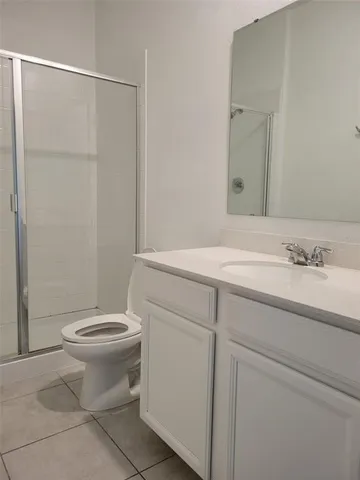 a bathroom with a granite countertop sink a toilet and a mirror