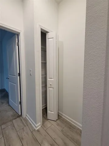 an empty room with wooden floor and entrance