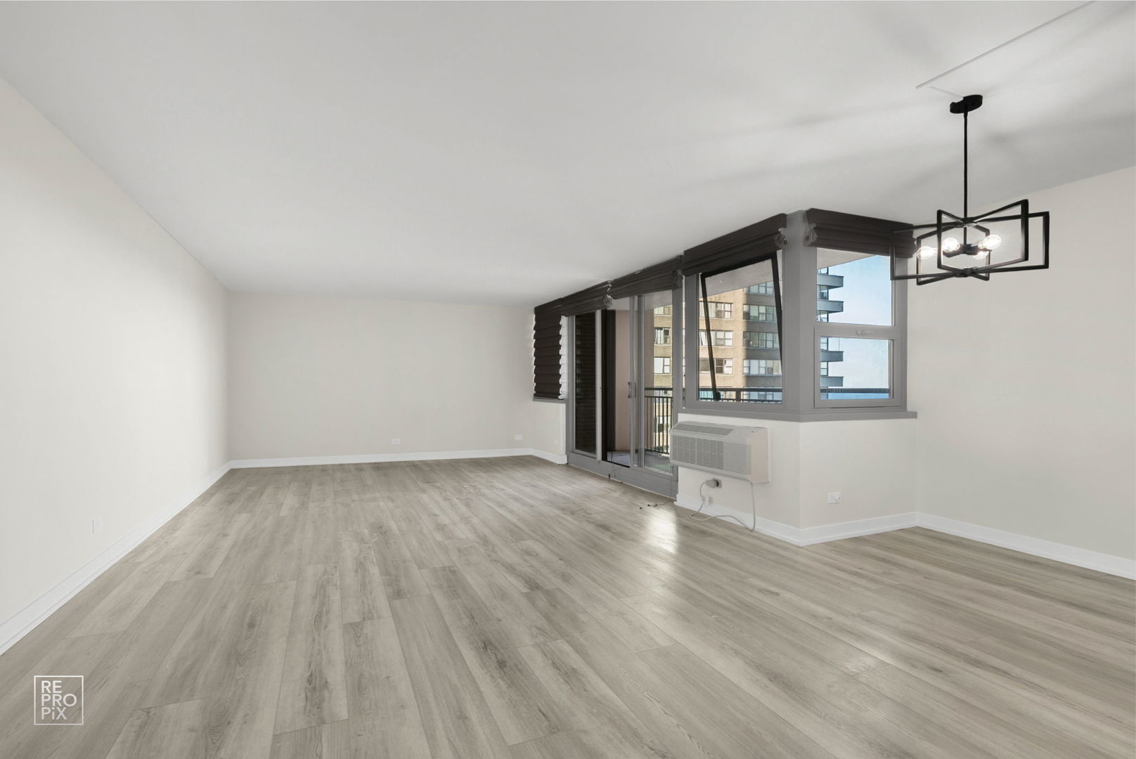 6147 North Sheridan Road, Unit 7A Chicago, IL 60660 - Photo 2 of 14 a view of an empty room with wooden floor and a window