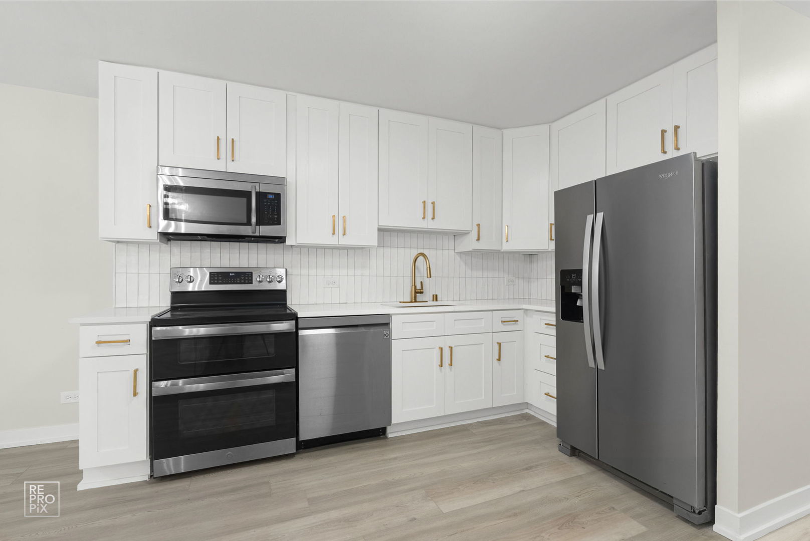 6147 North Sheridan Road, Unit 7A Chicago, IL 60660 - Photo 5 of 14 a kitchen with granite countertop white cabinets and stainless steel appliances