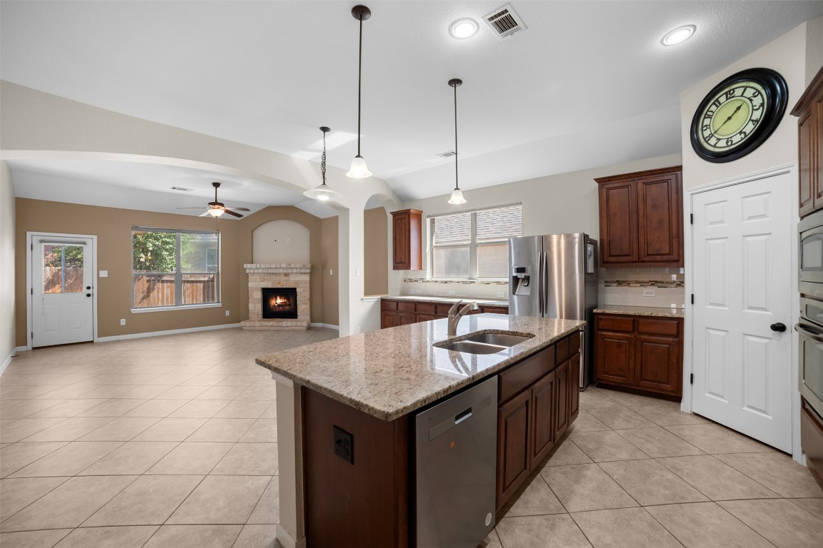 216 Archipelago Trail Austin, TX 78717 - Photo 13 of 40 Kitchen featuring decorative light fixtures, a ceiling fan, light tile patterned floors, and stainless steel appliances