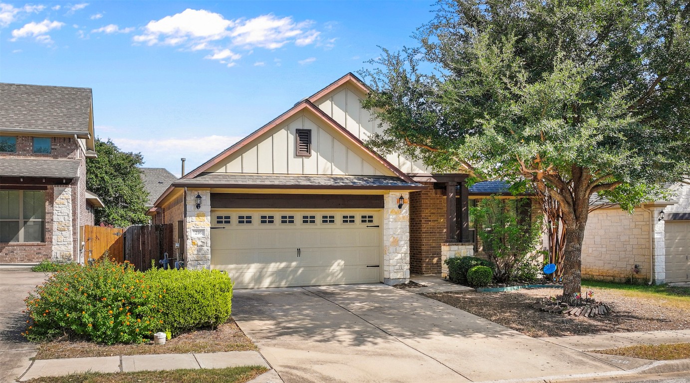216 Archipelago Trail Austin, TX 78717 - Photo 2 of 40 View of front facade featuring board and batten siding, stone siding, driveway, a shingled roof, and a garage