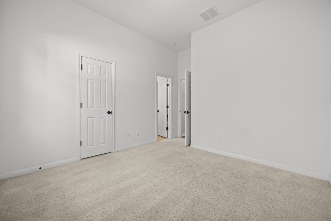 216 Archipelago Trail Austin, TX 78717 - Photo 22 of 40 Unfurnished bedroom featuring light carpet and baseboards