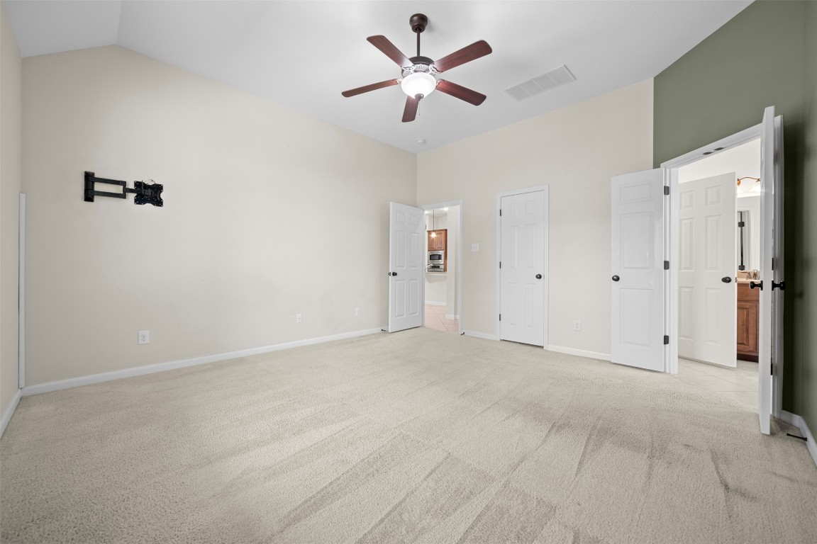 216 Archipelago Trail Austin, TX 78717 - Photo 24 of 40 Unfurnished bedroom featuring light colored carpet, ceiling fan, and lofted ceiling