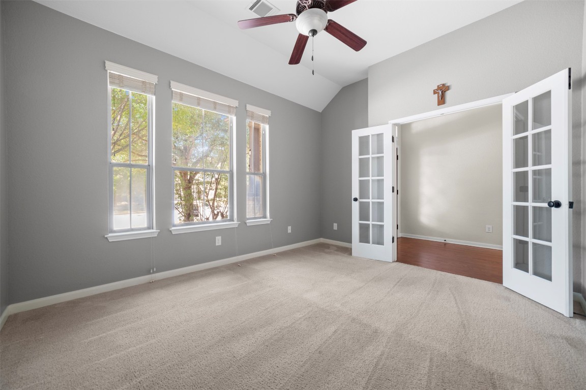 216 Archipelago Trail Austin, TX 78717 - Photo 26 of 40 Spare room with french doors, light carpet, a ceiling fan, and lofted ceiling
