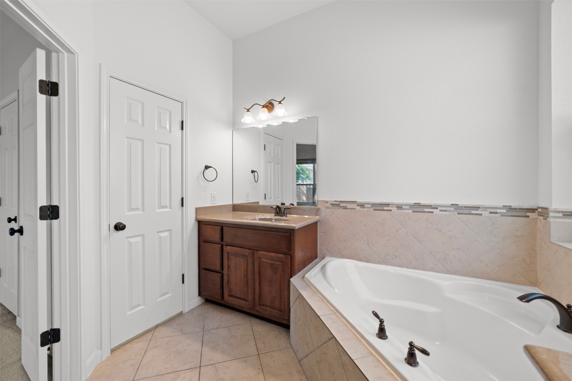 216 Archipelago Trail Austin, TX 78717 - Photo 29 of 40 Full bath featuring vanity, a garden tub, and light tile patterned flooring