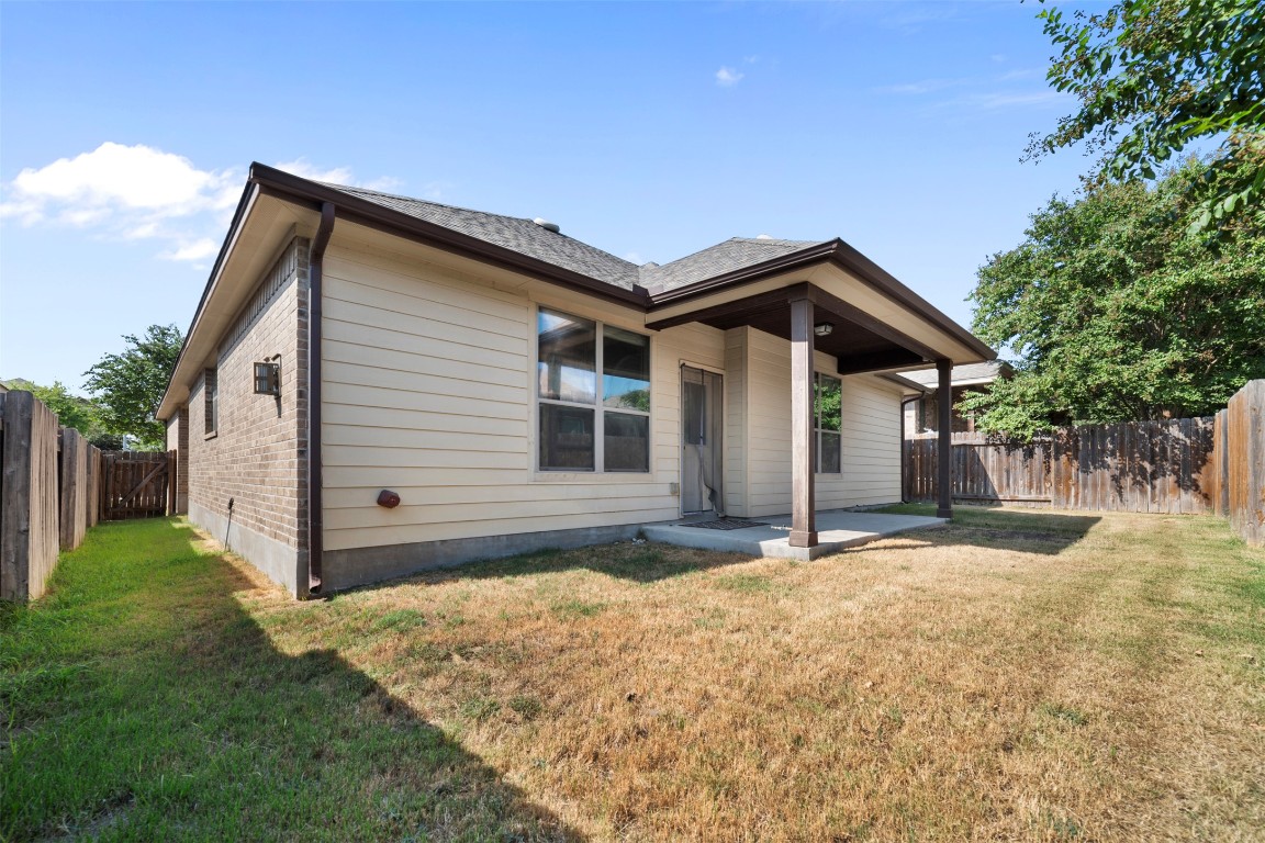 216 Archipelago Trail Austin, TX 78717 - Photo 39 of 40 View of front of property featuring a fenced backyard, a patio, a shingled roof, and brick siding