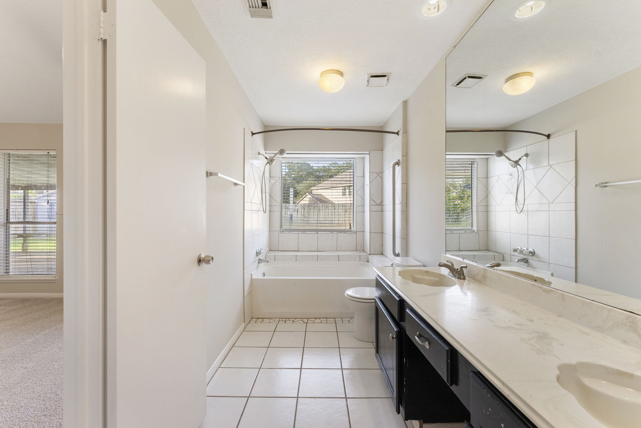5114 Aberton Lane Spring, TX 77379 - Photo 17 of 31 a bathroom with a granite countertop sink a mirror and a bathtub