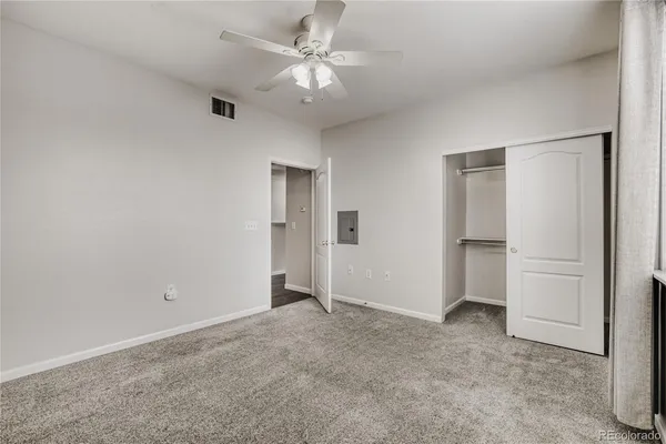 an empty room with closet and windows