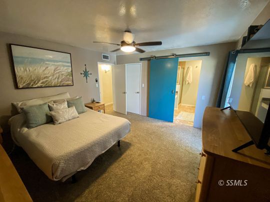 218 South Lilac Street Ridgecrest, CA 93555 - Photo 24 of 43 a bedroom with a bed and wooden floor