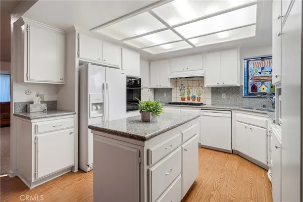 a living room with furniture floor to ceiling windows and wooden floor