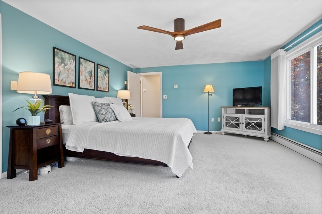 30 Davis Road Stow, MA 01775 - Photo 28 of 42 a spacious bedroom with a bed a couch and a flat tv screen on the dresser