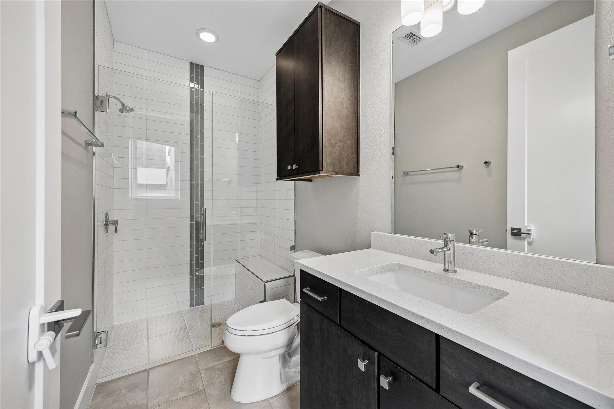 5006 Pecan Springs Road, Unit 6 Austin, TX 78723 - Photo 24 of 30 Modern bathroom featuring sleek dark cabinetry, white countertops, and a spacious glass-enclosed shower.