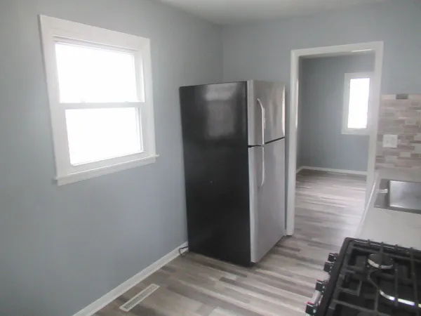an empty room with wooden floor cabinet and closet