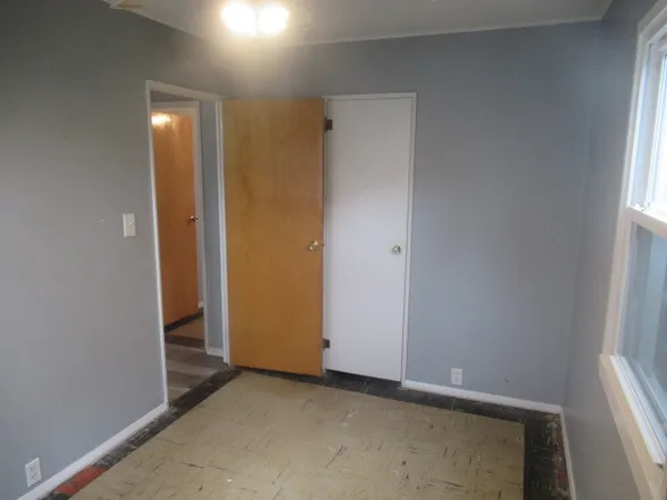 an empty room with mirror and a window