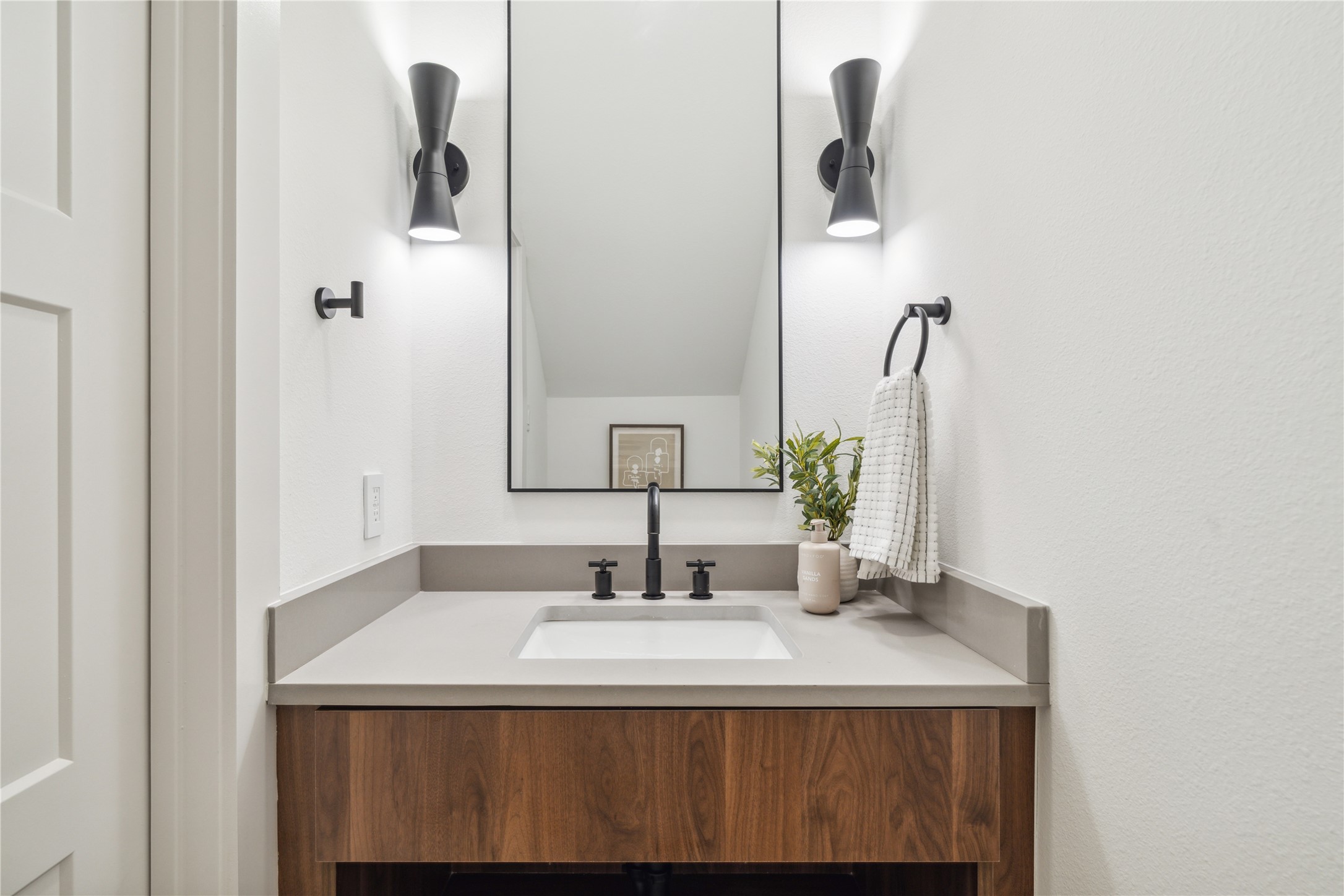 3415 Stonewall Street Houston, TX 77020 - Photo 12 of 50 Contrasting finishes and statement lighting elevate the powder room, offering a warm, designer-inspired moment in a compact space.