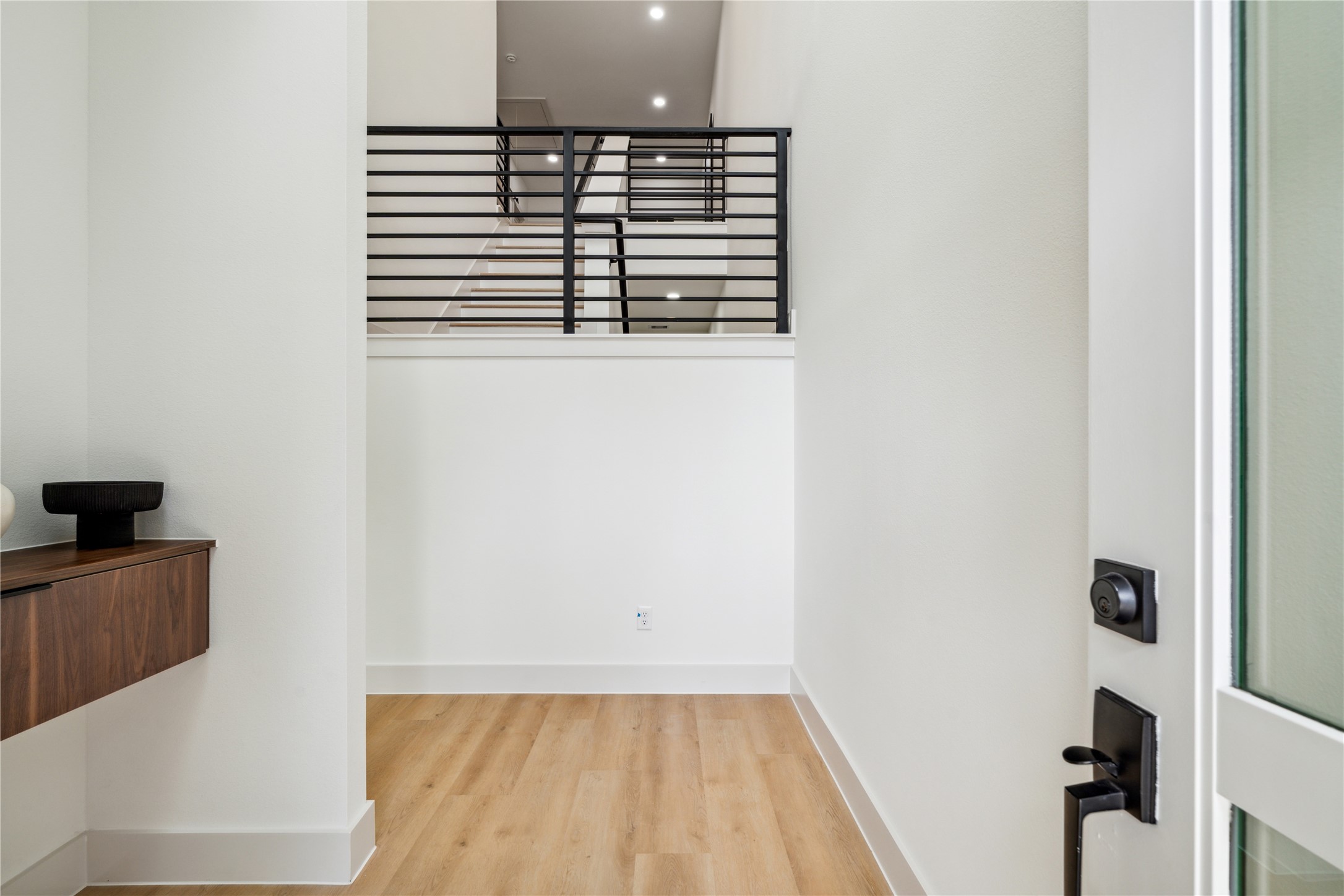 3415 Stonewall Street Houston, TX 77020 - Photo 7 of 50 Step into a striking foyer with crisp modern lines, elevated sightlines, and sleek built-in storage that sets a sophisticated tone from the moment you arrive.
