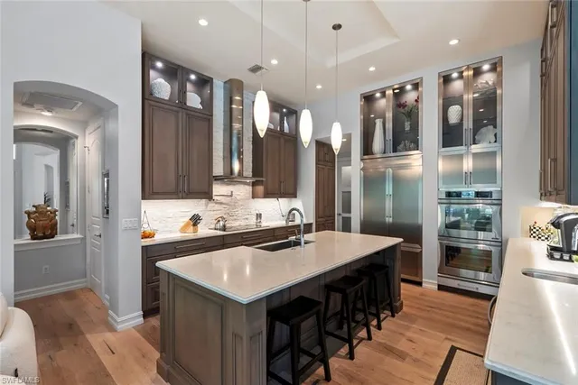 a kitchen with kitchen island a sink appliances and cabinets