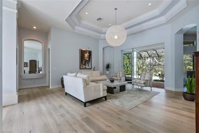 a living room with furniture wooden floor and a large window