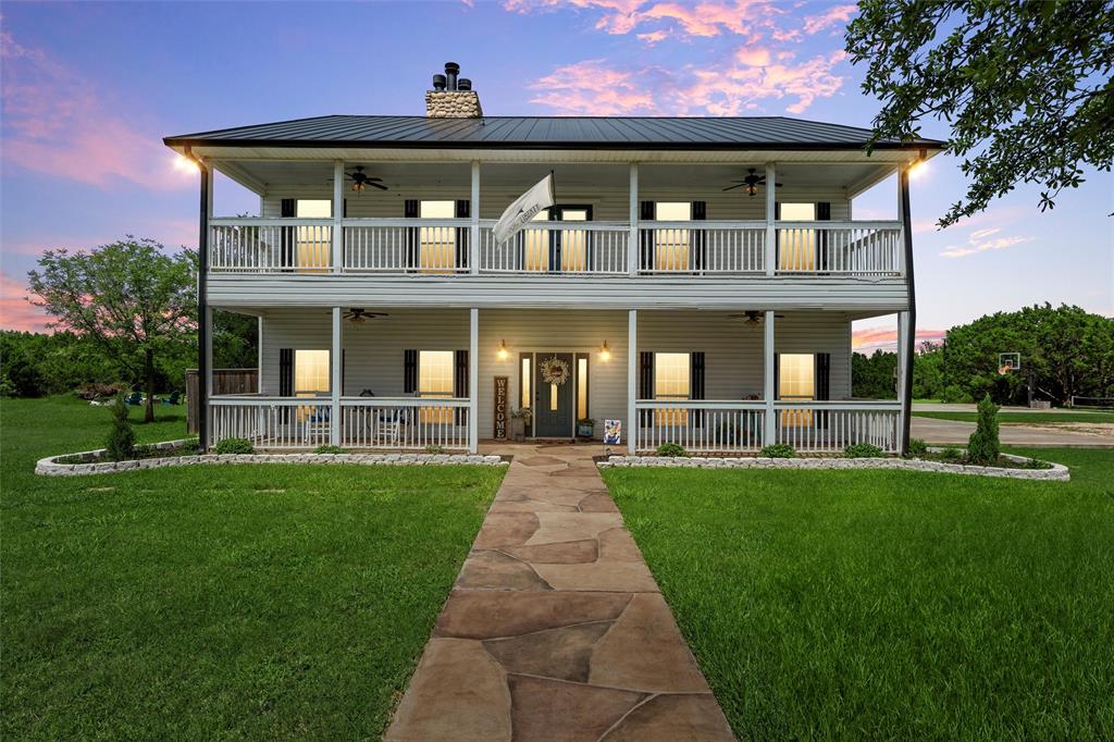 738 Old Ranch Road China Spring, TX 76633 - Photo 1 of 1 Back of property at dusk featuring a balcony, a porch, ceiling fan, and a lawn