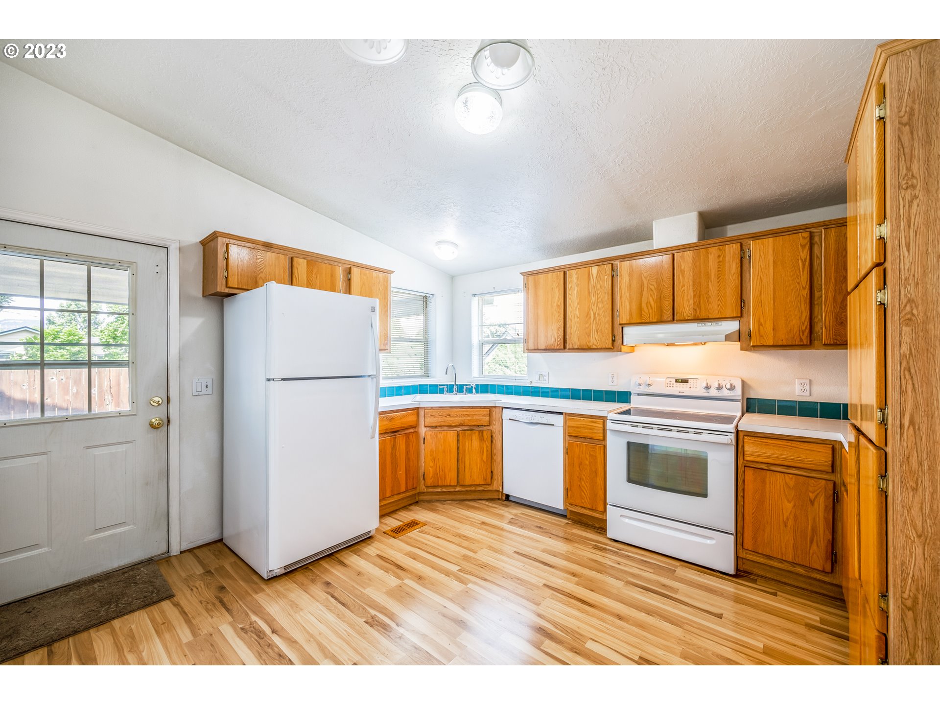 230 19th Street Springfield, OR 97477 - Photo 13 of 34 a kitchen with a refrigerator a stove top oven a sink dishwasher and wooden cabinets