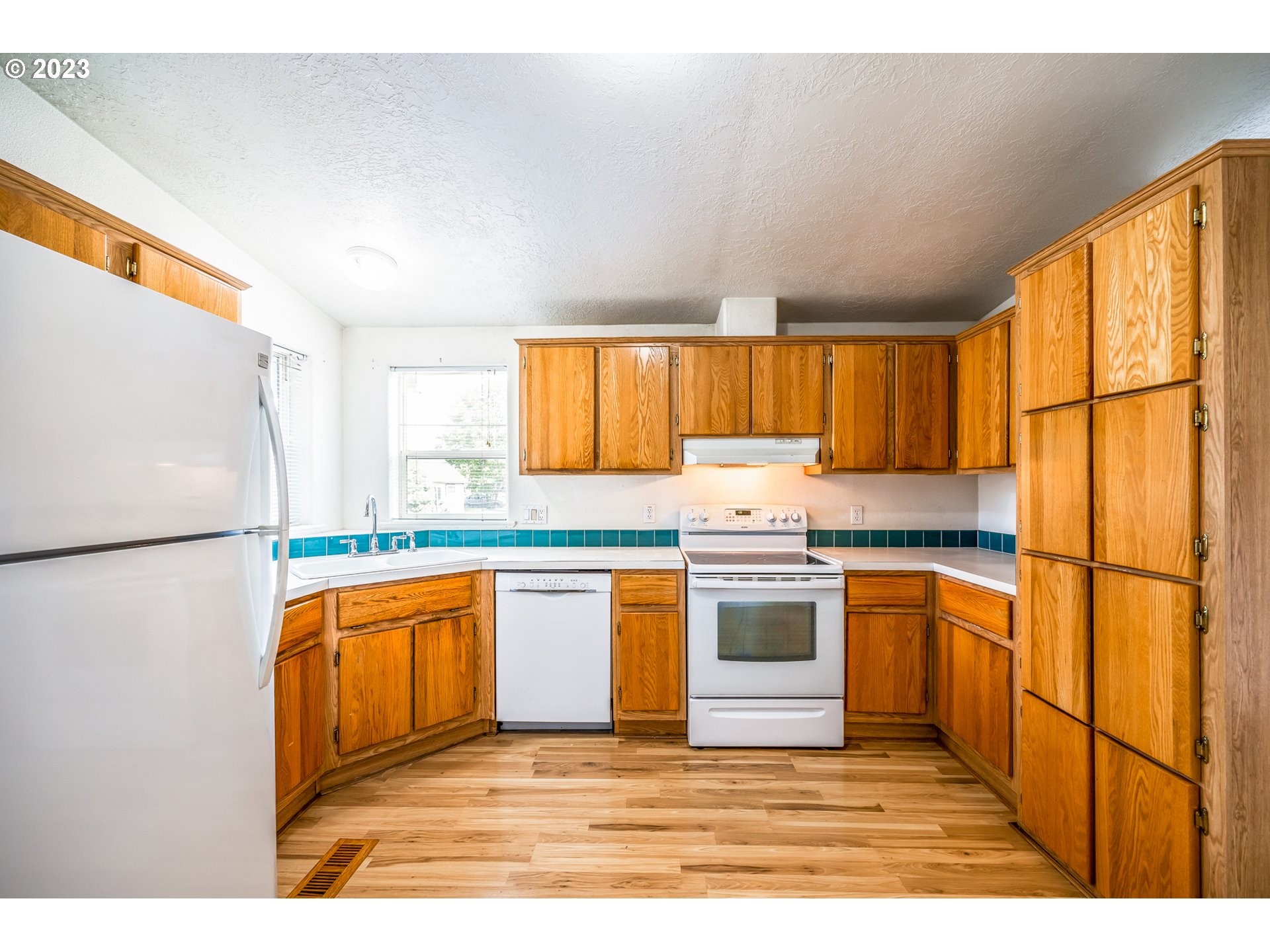 230 19th Street Springfield, OR 97477 - Photo 14 of 34 a kitchen with stainless steel appliances granite countertop a refrigerator a sink a stove a microwave and island