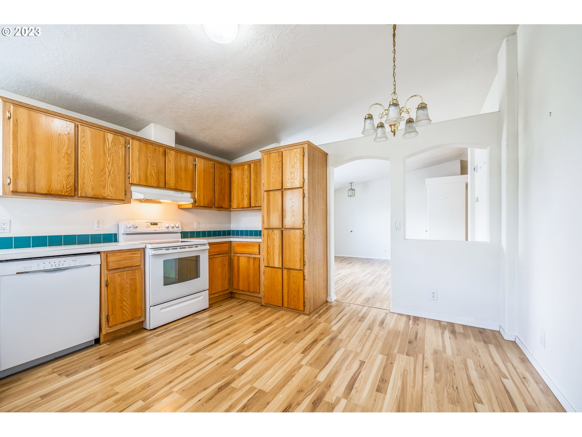 230 19th Street Springfield, OR 97477 - Photo 18 of 34 a kitchen with granite countertop a stove a sink dishwasher and a refrigerator with wooden floor