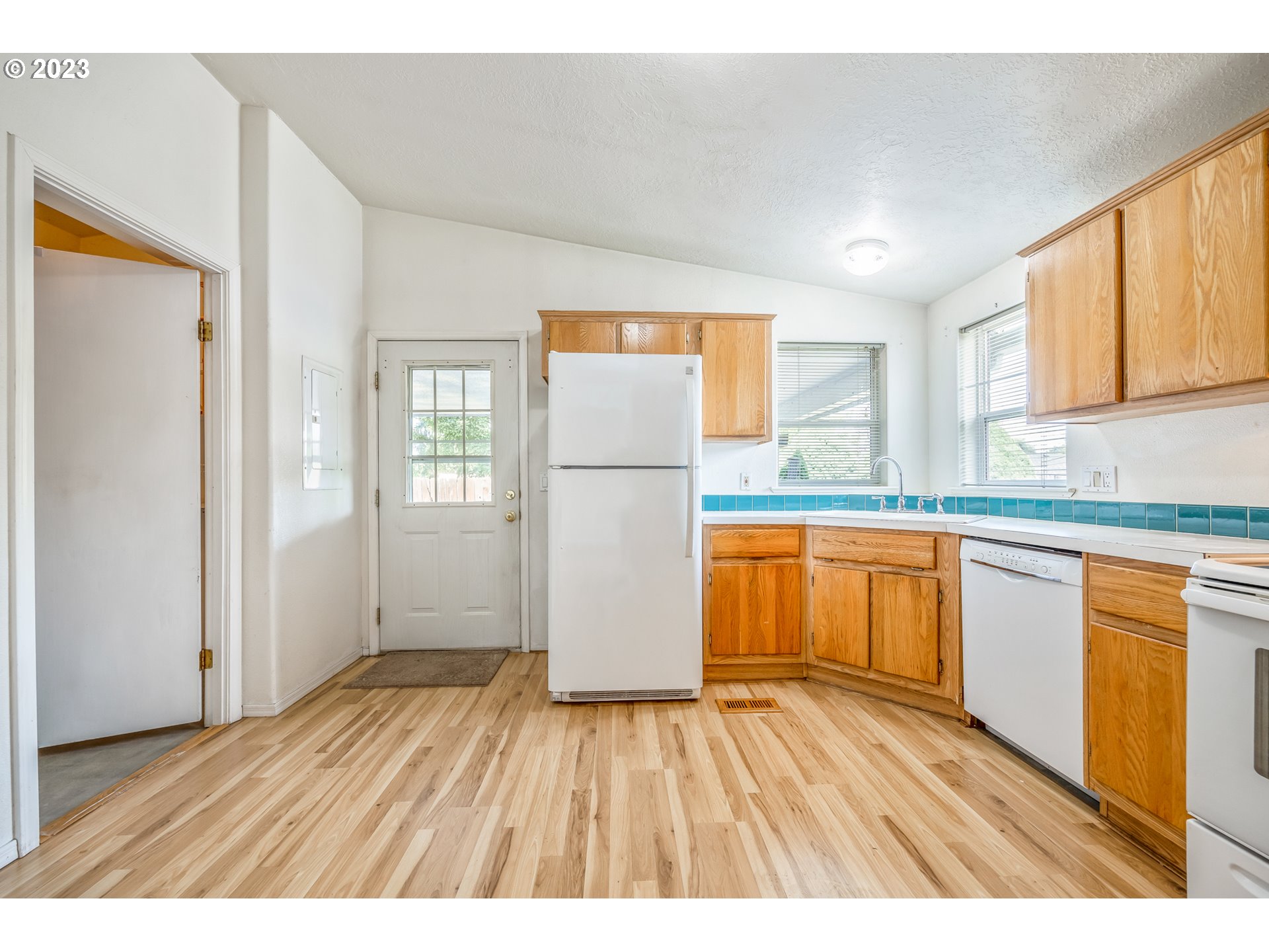 230 19th Street Springfield, OR 97477 - Photo 28 of 34 a kitchen with a wooden floor window and a refrigerator