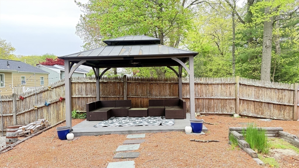 118 Spruce Road Norwood, MA 02062 - Photo 17 of 39 a view of a patio with a table and chairs under an umbrella with a small yard