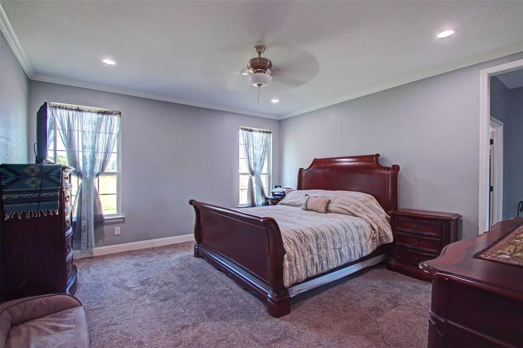 8789 Hutcheson Hill Road Springtown, TX 76082 - Photo 13 of 32 a bedroom with a bed and a chandelier