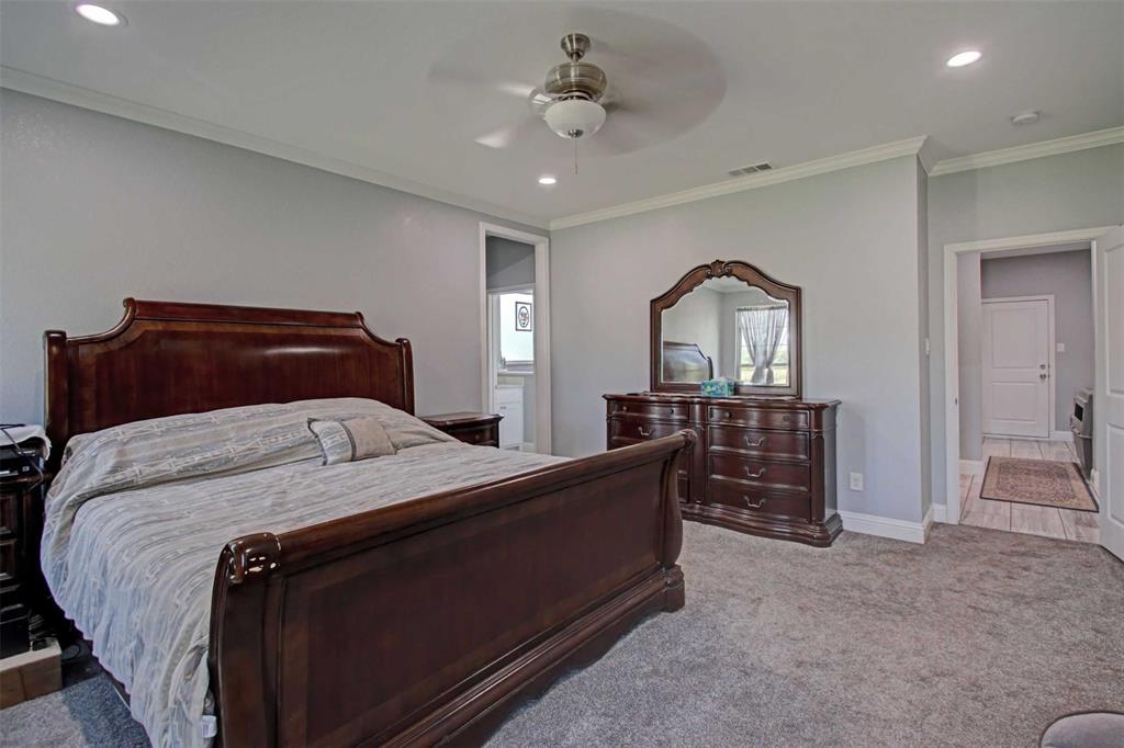 8789 Hutcheson Hill Road Springtown, TX 76082 - Photo 14 of 32 a bedroom with a bed and a chandelier