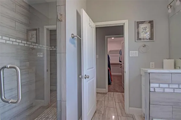 a walk in closet with clothes and shoes