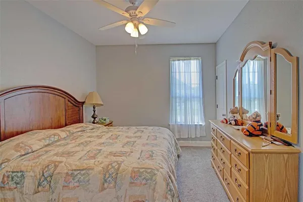 a view of an empty room with window and chandelier fan